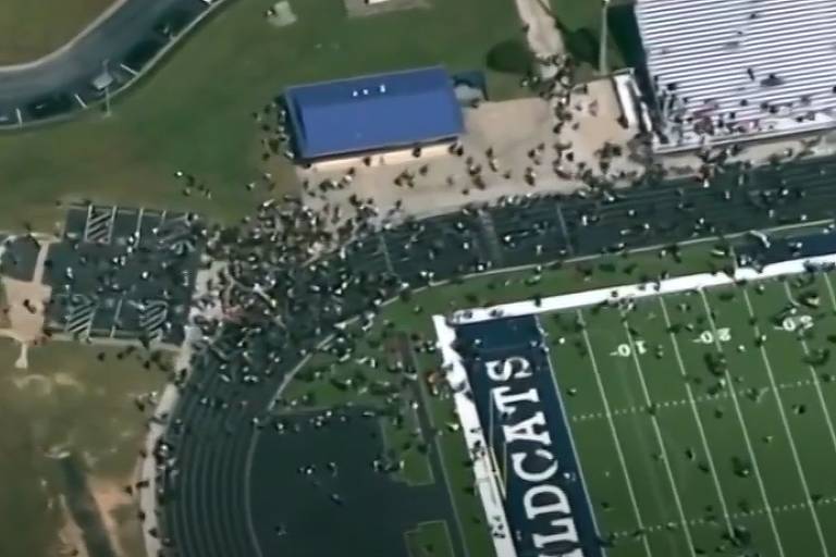 Pessoas em campo de futebol americano de escola em Winder, na Geórgia, após ataque a tiros, nos EUA