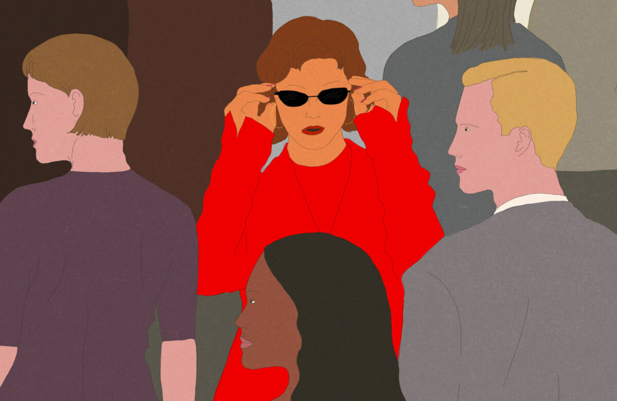 A imagem apresenta uma multidão de pessoas, onde a maioria está em tons neutros. No centro, destaca-se uma mulher com cabelo castanho e óculos escuros, vestindo uma blusa vermelha. Ela está ajustando os óculos, enquanto as outras figuras ao redor têm expressões neutras e estão vestidas de forma variada, em cores como cinza, preto e branco. O fundo é composto por várias silhuetas de pessoas, criando um contraste com a mulher em vermelho.